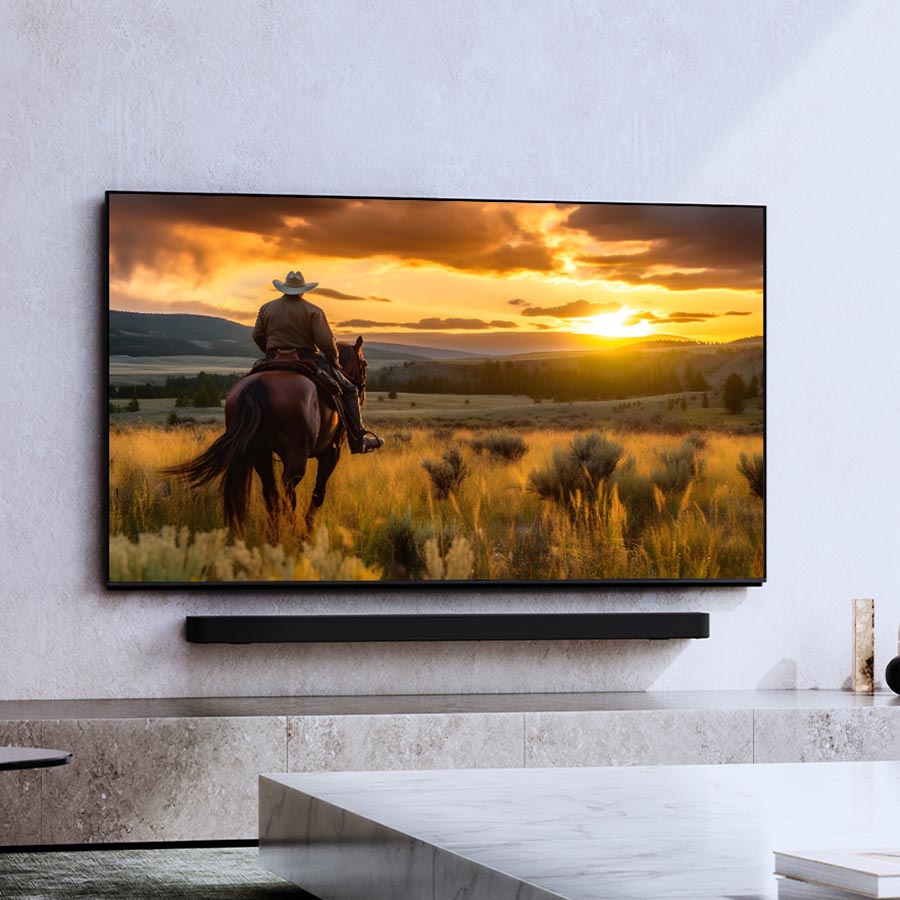 Wall-mounted TV displaying a scenic sunset view with cowboy on horseback