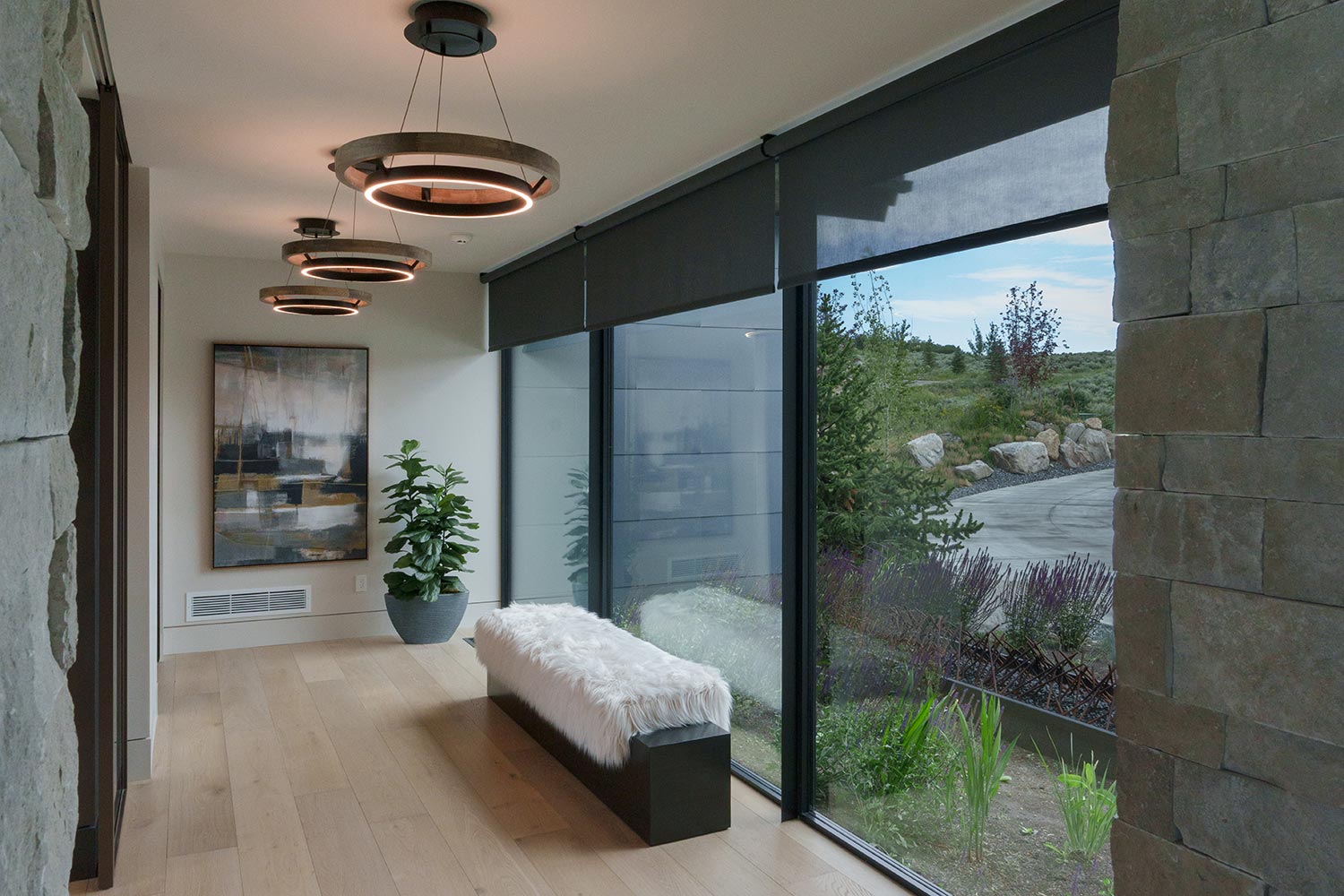 Hallway with modern ring pendant lights and large shaded windows