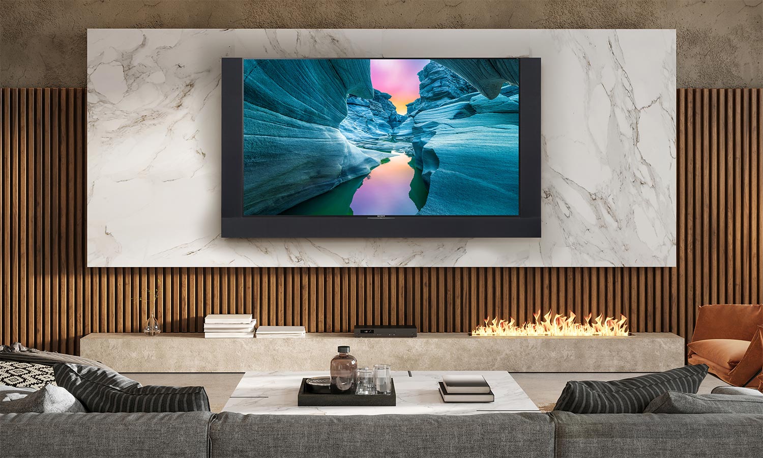 A spacious living room with a vaulted wooden ceiling, a large sectional sofa, and a TV mounted on the wall, offering a panoramic view through the glass doors.