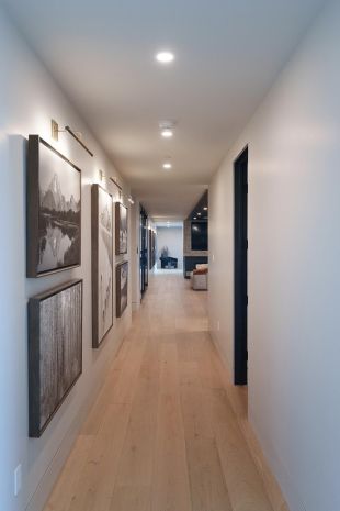 Modern Home hallway with black and white artwork on walls and custom Lutron Lighting