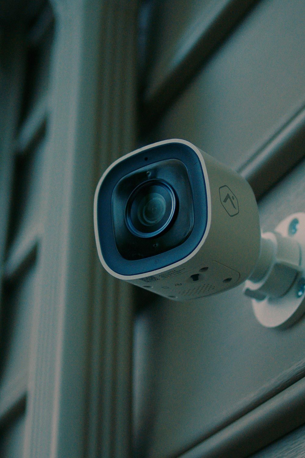 Close-up of an Alarm.com outdoor security camera mounted on the side of a building.