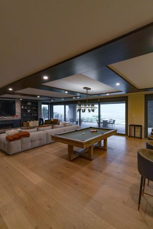 Modern dark and light wood game room with Lutron lighting and in-ceiling speakers