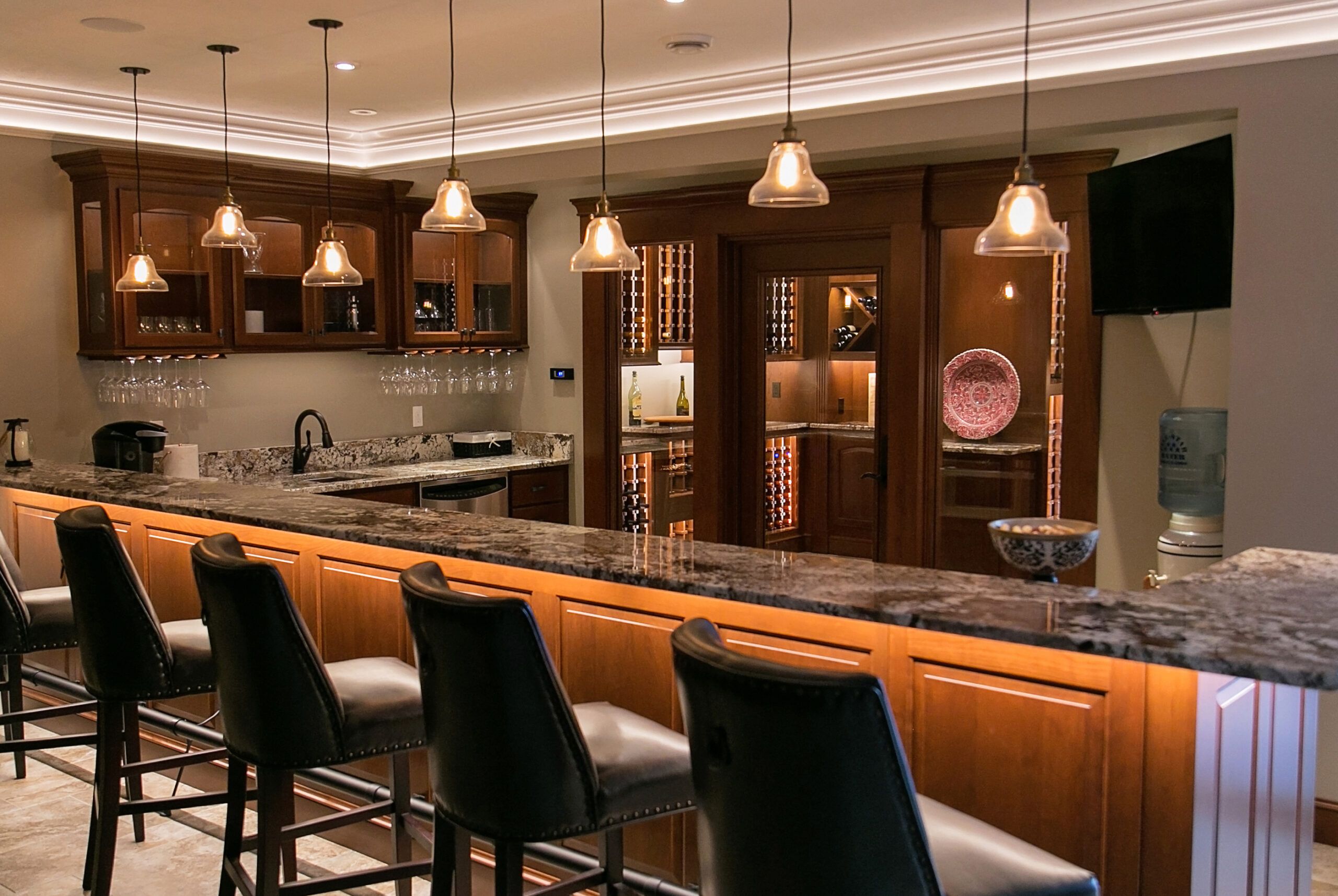 Kitchen bar with pendant lighting and under-the-counter LED lights.