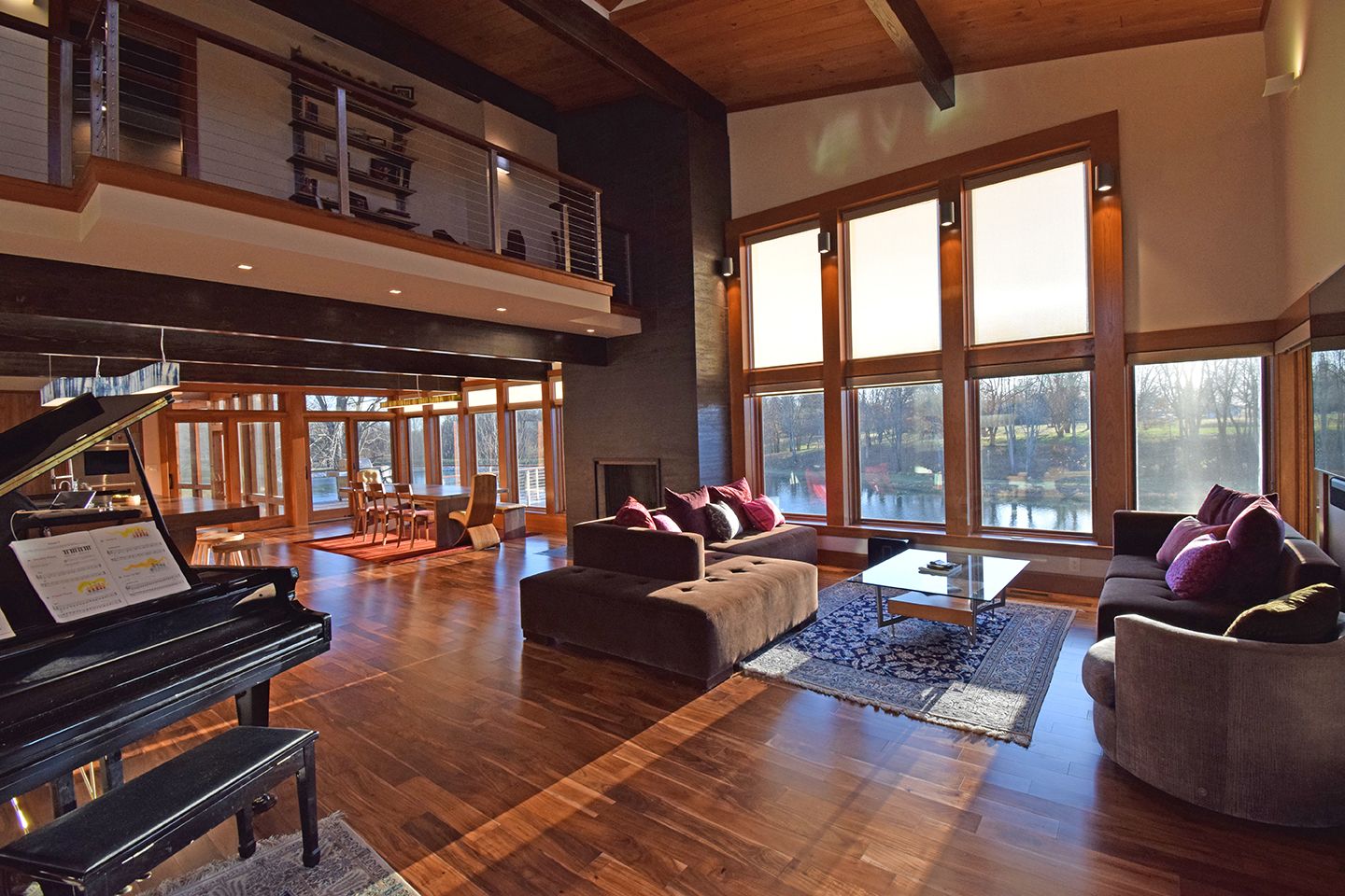 A spacious living room with floor-to-ceiling windows overlooking a scenic view.