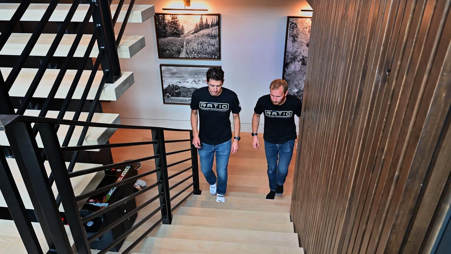 Two team members ascending a modern staircase in a well-designed home interior.